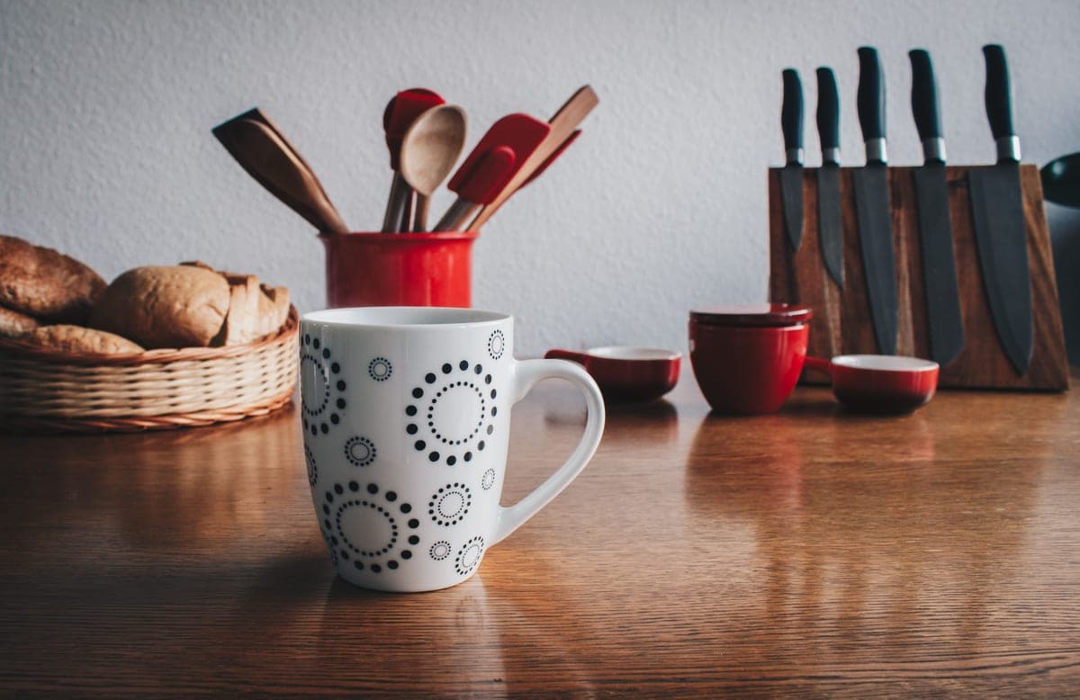An assortment of kitchen knives and tools on a wooden table