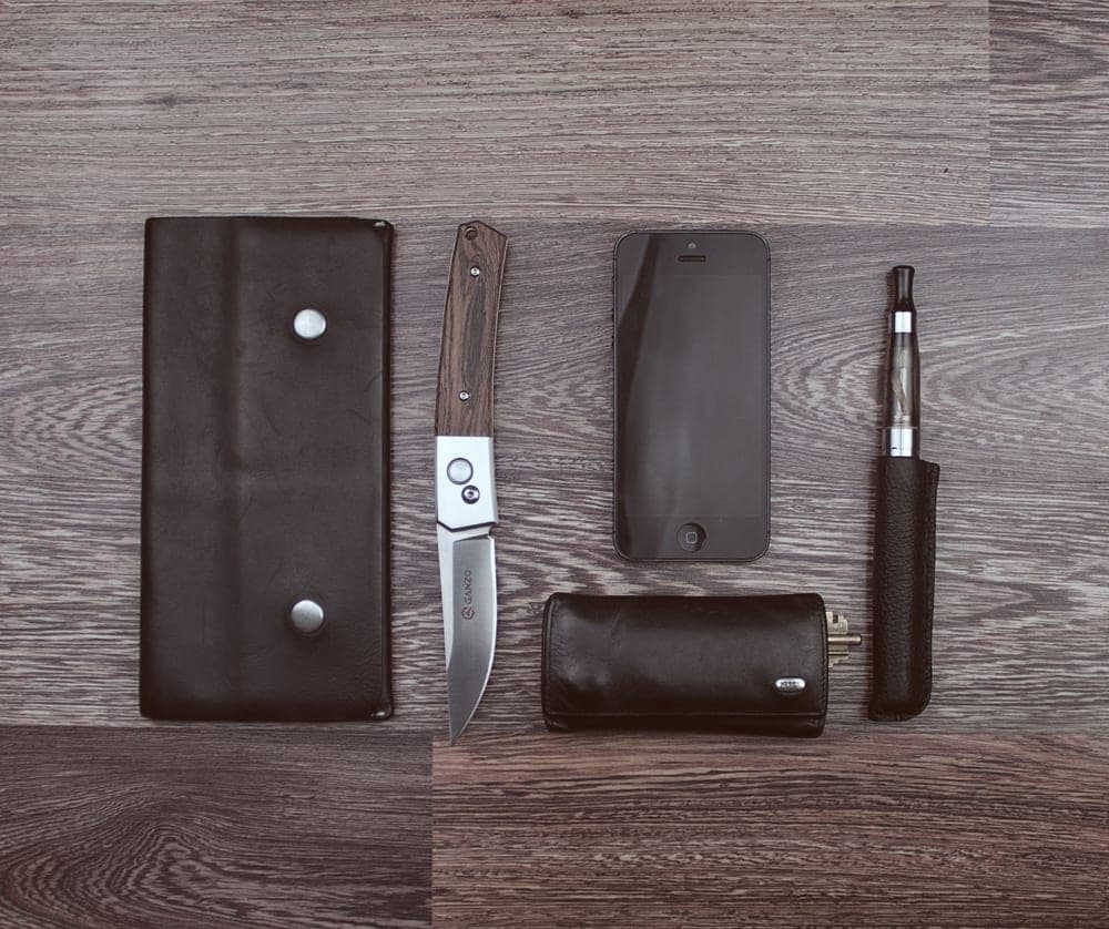 A leather strop and a knife resting on a wooden surface
